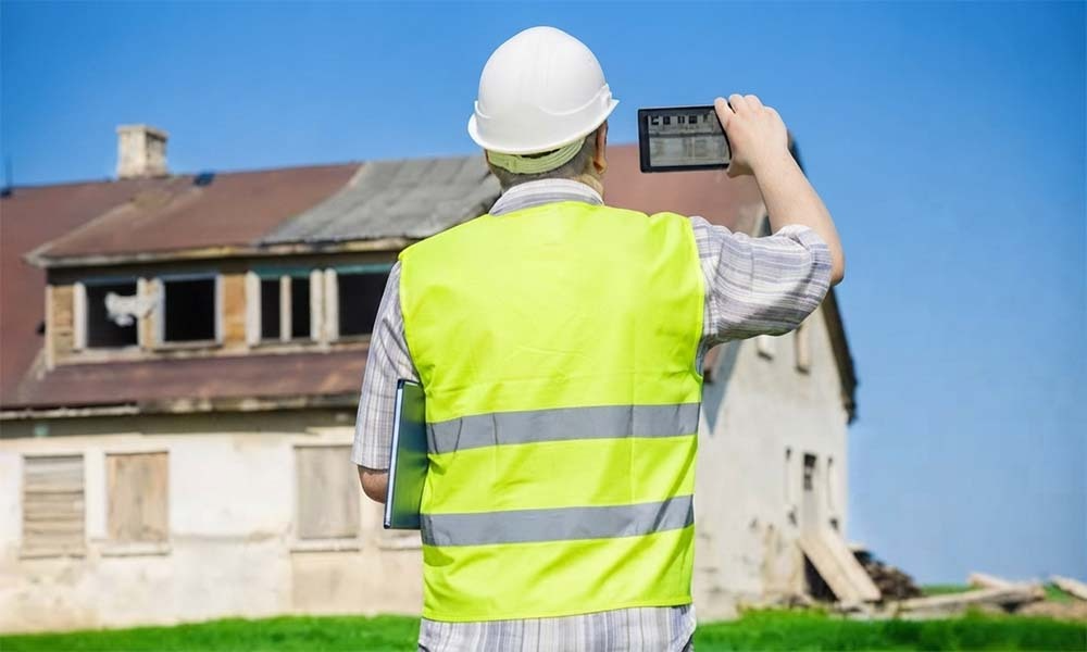 Inspector photographing old house